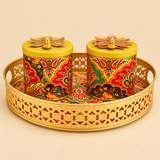 Brass gift tray with two lidded bowls featuring colourful paisley floral design, arranged on a round decorative tray with handles against a beige background.