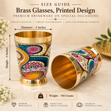 Size guide image for brass glasses with printed design premium drinkware on special occasions showing approximate dimensions of 4 inches diameter, 3 inches height and 700 grams weight. The image clearly presents the printed brass tumblers with measurement arrows and text details on a clean beige background to help customers understand the product size and proportions before purchase.