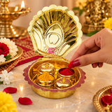 Brass Haldi Kumkum Box shown in a traditional puja setting with red kumkum and yellow haldi placed inside the individual containers, surrounded by diya, flowers and festive decor for daily worship, religious ceremonies, weddings and special occasions.