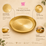 Product feature infographic titled 'TIMELESS TRADITIONS - BEAUTIFULLY YOURS' by Ashtok. Four circular callout badges highlight key details: 'Hammered Brass Finish' featuring handcrafted texture, 'Round Serving Tray' showing classic circular shape, 'Raised Rim' keeping items secure while serving, and 'Elegant Multipurpose Use' demonstrating the plate filled with a glowing brass diya oil lamp, marigold flowers, and small offerings.
