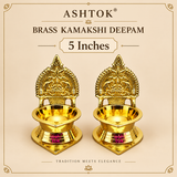 Brass Kamakshi Deepam pair displayed on a soft beige background with elegant product styling and text indicating the 5 inch size. Both lamps feature a polished brass body, traditional carved back design, rounded bowl for oil or wick placement, and a solid stepped base. The image highlights the graceful proportions, devotional appeal, and timeless brass craftsmanship, making the set suitable for pooja rituals, festive décor, and gifting.