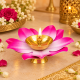 Brass Kamal Diya shown in use in a warm traditional puja setting with a gently burning wick flame in the polished brass bowl, surrounded by tasteful white flowers, rose petals and festive brass decor on a beige surface, demonstrating practical use for daily worship, Akhand diya lighting, Diwali celebrations, evening aarti, home mandir rituals and festive ceremonies without any deity idol included in the scene.