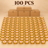 Brass Kuber Diya Pack of 100 Pcs displayed as a large bulk collection of traditional golden brass pooja oil lamps arranged in numerous organised rows with simple brown cardboard packaging boxes against a warm premium beige studio background. Each decorative brass diya features a polished golden bowl-shaped oil reservoir, smooth reflective interior, pointed wick spout, intricately engraved geometric detailing around the outer rim, and a compact stable circular pedestal base.