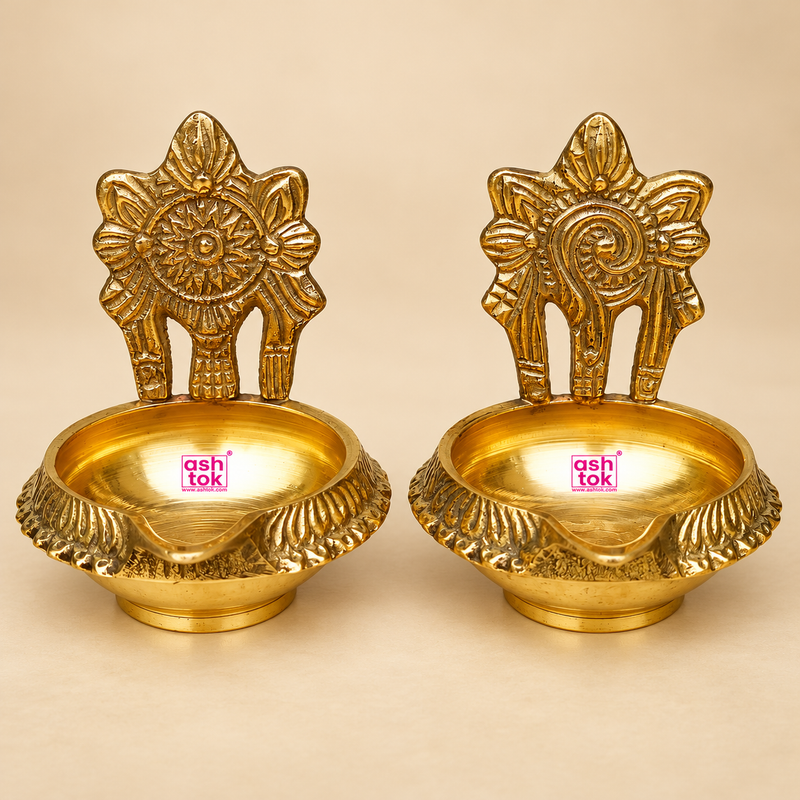 Set of 2 Brass Kuber Diyas with a polished golden finish, deep round oil bowl, floral embossed backplate and decorative textured rim. Traditional tabletop brass diyas suitable for pooja, festive decoration, Diwali celebrations, home temple use and gifting. Each diya measures 2.5 inches in diameter and 3 inches in height.