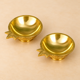 Elevated top-view photograph of a Brass Kuber Diya Set of 2 Pcs highlighting the smooth polished golden interiors of two matching traditional brass oil lamps. Each diya features a broad rounded oil-holding bowl, decorative pointed wick spout along the outer rim, finely finished circular edges, ornamental floral engravings on the exterior, and a small sturdy pedestal base. The reflective golden brass finish highlights the traditional Kuber diya design, making these compact pooja lamps suitable for daily devo