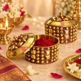 Lifestyle image of Brass KumKum Box displayed in a festive pooja setting with kumkum powder, diya, flowers and traditional décor on a warm beige background.