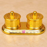 Brass Kumkum Box with two round covered compartments on a decorative oval base, featuring embossed traditional patterns, polished golden finish and individual lids, professionally presented on a premium beige studio background for puja and home temple use.