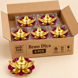 Twelve piece bulk gifting pack of decorative brass lotus diyas arranged neatly inside an open cardboard box, showing the golden brass oil bowls, central wick holders, gold leaf shaped lotus petals and vibrant magenta floral bases with protective packaging, designed for convenient bulk ordering for Diwali, puja ceremonies, festive return gifts, weddings, housewarming events and corporate gifting.