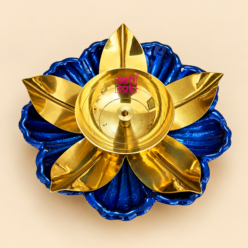 Traditional brass lotus diya for puja and Diwali featuring a beautifully polished golden brass oil bowl with a central wick holder, surrounded by elegantly curved golden lotus petals and a vibrant royal blue flower-shaped decorative base. Measuring 6 inches in diameter and 1.5 inches in height, this traditional decorative oil lamp is ideal for daily prayers, home mandir decoration, Diwali celebrations and festive gifting.