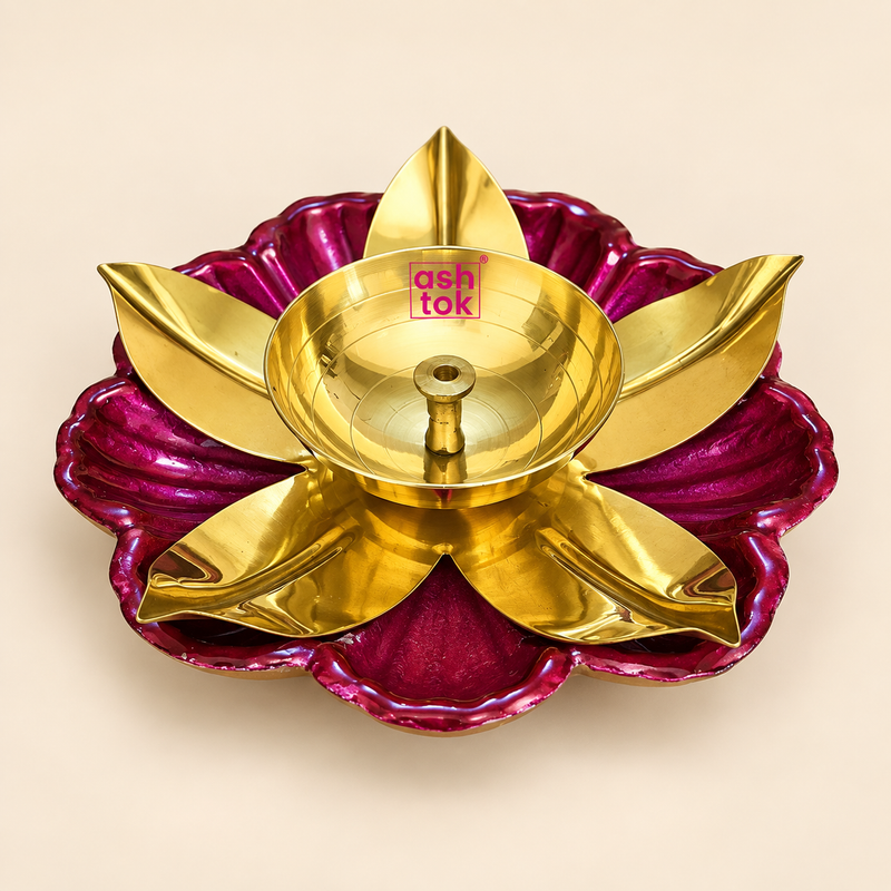 Brass lotus diya for puja and Diwali featuring a polished golden brass oil lamp bowl with central wick holder, decorative gold leaf shaped petals and a deep magenta flower shaped outer base, photographed individually on a clean warm beige studio background for festive home decoration, daily pooja, religious ceremonies, traditional Indian festivals, return gifts and gifting occasions.
