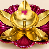 Close-up detail view of a decorative brass lotus diya highlighting the polished golden brass oil bowl, central wick holder, smooth reflective metal finish, sculpted gold leaf shaped petals and rich magenta flower shaped outer base, showing the craftsmanship and decorative detailing suitable for puja, Diwali decoration, festive use, traditional gifting and home temple accessories.