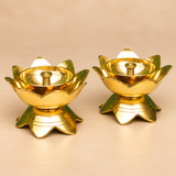 Side-profile product photograph of two Brass Lotus Diyas featuring a polished golden brass finish, wide lotus-petal oil bowls, decorative pointed flower petals, raised circular inner reservoirs, and matching lotus-inspired pedestal bases. The side perspective highlights the fine horizontal decorative lines, smooth rounded bowl structure, and stable base design. Each diya measures 3 inches in diameter and 2 inches in height, making this matching pair suitable for traditional pooja arrangements, Diwali lighti