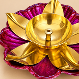 Detailed close-up view of a traditional brass lotus diya highlighting the polished golden oil bowl, central cotton wick holder, smooth curved brass petals and decorative pink lotus-shaped base with textured floral detailing. Designed for traditional puja rituals, Diwali lighting and decorative home mandir arrangements.
