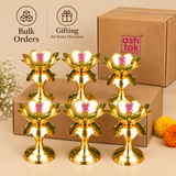 Bulk gifting presentation featuring six traditional Brass Lotus Diya Stands arranged with simple cardboard packaging on a beige background. Each golden brass diya stand measures 2.5 inches in diameter and 5.5 inches in height, with a decorative lotus flower bowl, polished brass petals, central wick holder and stable round pedestal base. Suitable for wedding return gifts, housewarming gifts, Diwali gifting, festive giveaways, pooja ceremonies, traditional Indian celebrations and bulk gifting requirements.