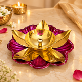 raditional brass lotus diya with a polished golden finish and decorative pink flower-shaped base displayed on a marble surface in an elegant festive setting. Surrounded by jasmine flowers, soft decorative lighting and traditional puja accessories, making it suitable for Diwali celebrations, daily worship and home temple decoration.