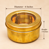 Size guide of a traditional round brass masala storage box featuring a golden brass cylindrical body and removable circular lid with a transparent viewing window. The container measures 6 inches in diameter and 3 inches in height, providing a compact single-compartment storage design suitable for keeping whole spices, dry fruits and other kitchen essentials organized.