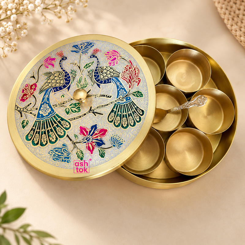 Brass masala box with 7 compartments featuring a decorative meenakari peacock design on the lid, round brass body, inner spice bowls and spoon, professionally displayed on a premium beige studio background for a clean Shopify product presentation.