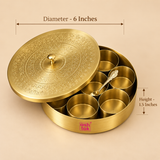 Size guide image of a round brass masala box showing approximately 6 inches diameter and 1.5 inches height, presented on a warm beige studio background with clear measurement arrows. The traditional spice storage box includes seven removable brass bowls, a matching serving spoon and an intricately engraved lid with a small central knob.