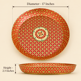 Product dimension diagram displaying a top-down and profile view of a round handcrafted brass tray with red and gold Meenakari floral artwork. Black arrows indicate a diameter of 17 inches and a side wall height of 2.5 inches against a beige background.