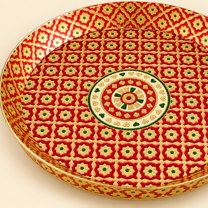 Detailed close-up photograph highlighting the intricate red and gold floral lattice work and central circular medallion pattern of a handcrafted brass Meenakari tray with raised sides, set on a cream background.