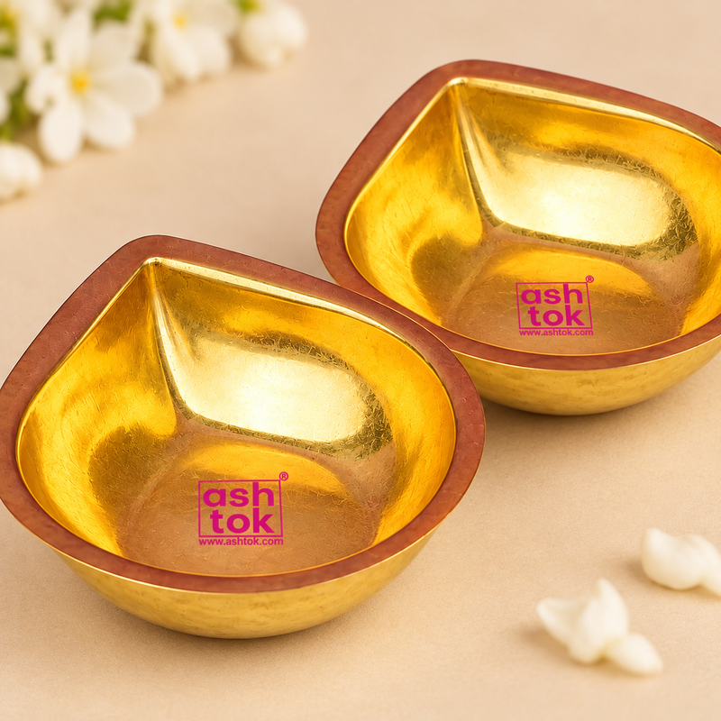 Side view of a pair of Brass Pankti Puja Diyas showing their shallow curved body, golden brass exterior and traditional copper-toned rim.