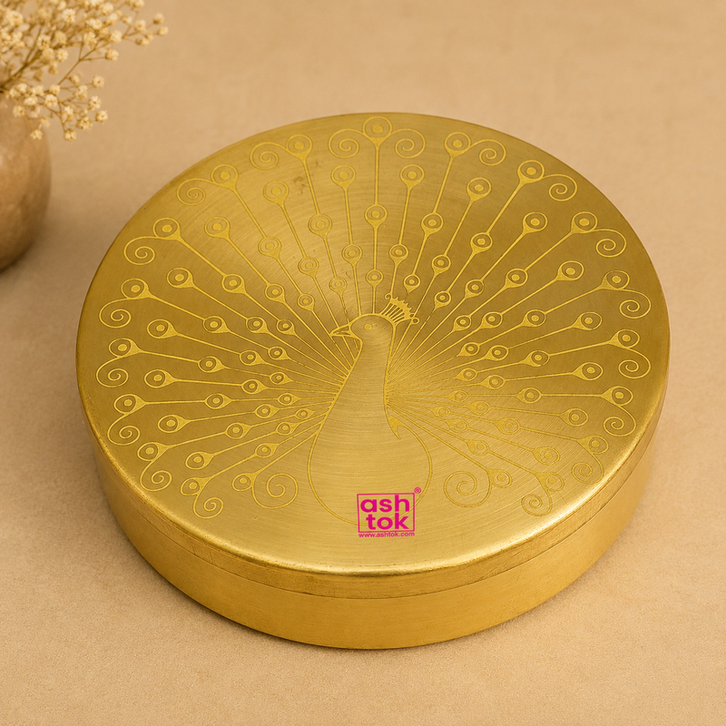Handcrafted round brass spice box (masala dabba) with engraved peacock design, ideal for storing spices, dry fruits, mouth fresheners, and traditional kitchen essentials.