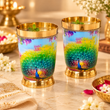 Peacock printed brass water glasses styled with chilled water, ice and fresh mint in an elegant festive setting, showing their use for serving water and beverages during celebrations, dining and special occasions.
