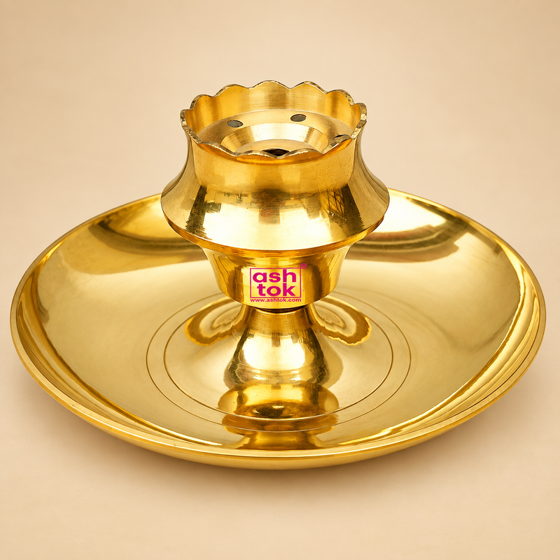 Traditional polished brass diya with a wide circular plate base, raised central pedestal, flower-shaped upper holder with scalloped rim, multiple small ventilation holes and a central opening for wick placement, photographed as a clean front-facing product image on a premium beige studio background with warm golden reflections and soft shadows, suitable for daily puja, home mandir use, festive worship, aarti, religious ceremonies, Diwali lighting, traditional decor and devotional gifting.