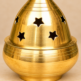 Detailed close-up of traditional Brass Piyali Akhand Deep featuring a shiny golden brass surface, smooth rounded oil reservoir, finely engraved circular grooves, and decorative star-shaped openings on the removable dome cover. The elegant brass diya design is suitable for home mandirs, daily devotional rituals, festive pooja arrangements, and spiritual decor.