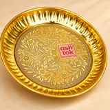 Detailed close-up of handcrafted brass puja plate highlighting the intricate floral engraving, fine etched pattern, polished golden surface and decorative fluted rim craftsmanship.