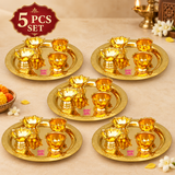 Five piece set display of brass puja thali sets arranged neatly on a beige background for gifting and bulk purchase.