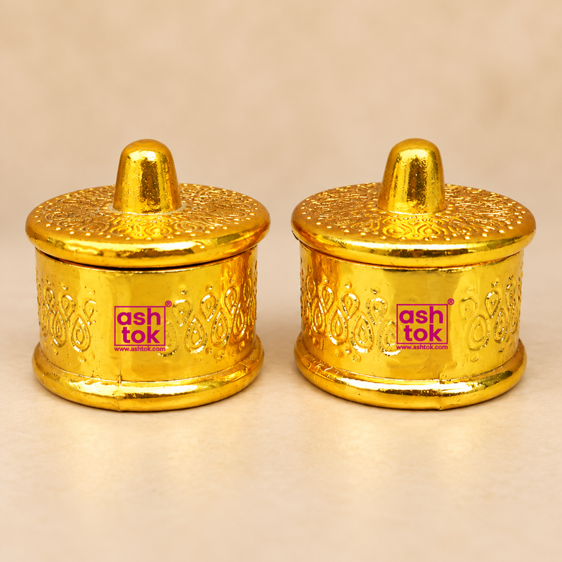 Brass Sindoor Box with round shape, hinged decorative lid, embossed traditional detailing and polished golden finish, shown as a matching pair on a premium beige studio background for puja, sindoor and kumkum storage.