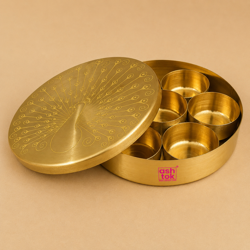 Open handcrafted brass spice box (masala dabba) with engraved peacock lid and removable spice containers, ideal for storing Indian spices, dry fruits, herbs, and mouth fresheners.