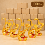 Bulk presentation of 100 Brass Swan Spoon Stands with multiple gold coated decorative swan holders displayed in front of plain packaging boxes. Suitable for wholesale orders, wedding return gifts, corporate gifting, festive events, large functions and high quantity gift distribution.