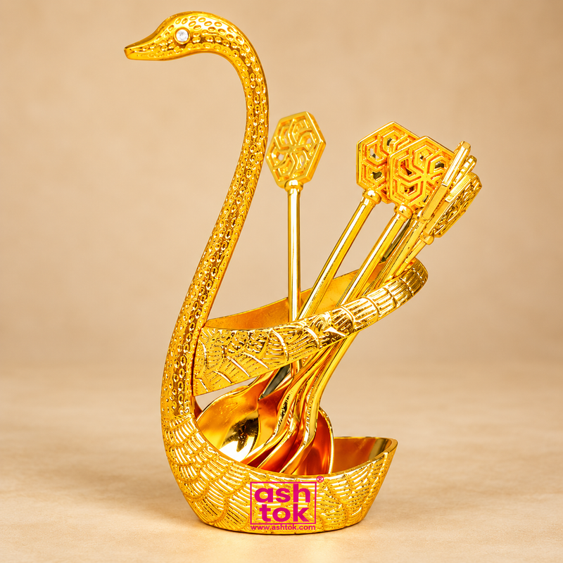 Brass Swan Spoon Stand with gold coated decorative finish featuring an elegant swan-shaped holder with long curved neck, detailed feather texture and matching golden decorative spoons. Professionally presented on a premium beige studio background, suitable for dining table decor, festive serving, gifting and elegant home decoration.