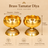 Brass Tamatar Diya size guide illustrating the product dimensions of 2 inches in diameter and 2.5 inches in height. The traditional golden brass diya features a rounded tomato-shaped oil bowl, decorative scalloped rim, raised central wick holder, finely engraved exterior grooves, and a wide fluted pedestal base. The measurement illustration helps customers understand the compact dimensions of this decorative brass pooja lamp for home temples, daily worship, and festive religious ceremonies.