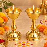 Brass Udupi Nanda Diya set of 2 shown in a festive pooja setting with lit flames, marigold flowers, and traditional decor, demonstrating its use for daily पूजा, festive rituals, temple decor, and spiritual occasions.
