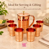 Feature image of a Copper Jug and 6 Glasses set showing a polished copper jug with lid, comfortable curved handle and six matching copper tumblers, with callouts highlighting the jug with lid, smooth handle grip, polished copper finish and complete set of six matching glasses, displayed on a soft beige background with ASHTOK branding to clearly communicate the product construction, matching design, reflective copper appearance and suitability for everyday drinkware, traditional serving, family use and gifti