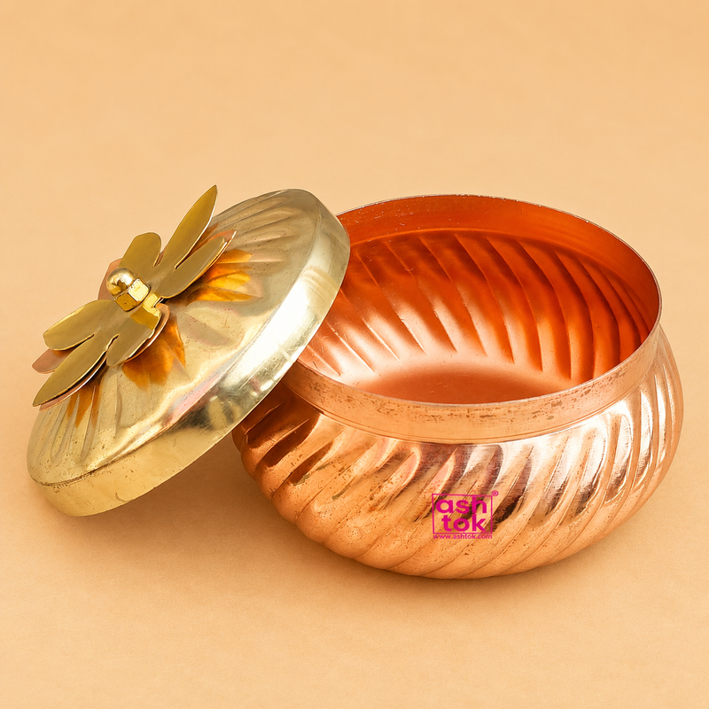 Open copper kalash shaped storage container with decorative brass lid on a beige studio background, handcrafted traditional kitchen storage box by Ashtok.