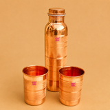 Pure copper water bottle with two matching copper glasses set, handcrafted Ayurvedic drinkware for healthy water storage, home, office, travel, and gifting.