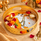 Cow Design Tray Flower Basket and Puja Tray for Temple displayed in a devotional lifestyle setting with flowers, diya, kumkum and rice, showing its use for daily puja, temple offerings, prasad presentation and festive rituals. The round golden tray features decorative cutwork sides, side carry openings and traditional white cow artwork for an auspicious and elegant presentation.