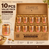 Ten piece pack of decorative dry fruit gift jar boxes arranged neatly in individual compartments inside a premium beige presentation box for return gifting and larger festive orders. Each matching jar features a polished copper-toned body, intricate floral and leaf cutwork design, rounded lower profile and a decorative golden lid finished with layered flower petals and a small spherical knob. 