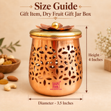 Size guide image of a decorative dry fruit gift jar box displayed on a warm beige background with clear product measurements showing approximately 3.5 inches diameter and 4 inches height. The compact storage jar features a polished copper-toned body with intricate floral cutwork, smooth rounded base, golden lid and decorative layered flower top with a round knob. Measurement arrows clearly indicate the overall diameter and height so customers can easily understand the compact product size before purchase. 