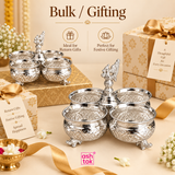 German silver chopala gift item with 4 attached bowls displayed in a festive bulk and gifting composition with multiple units, decorative beige gift boxes, ribbons, floral accents and elegant celebration styling, showing the product as an ideal choice for return gifts, festive gifting, event gifting, wedding gifting, premium giveaways and bulk orders, while clearly presenting its polished German silver finish, embossed bowl design, ornamental feet and traditional center finial with ASHTOK branding.