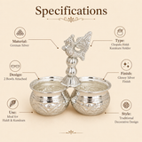 Product specifications infographic for a traditional German Silver Chopala Haldi Kumkum holder. The image features a glossy silver, two-bowl attached holder with an ornate center handle, surrounded by highlighted specifications detailing its material, design, use, type, finish, and style.