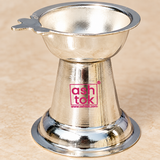 Bulk gifting presentation image showing multiple matching German Silver Diyas arranged neatly on a beige background with elegant festive gift styling, ribbon details and a premium gift box, highlighting their polished silver finish, shallow bowl design, wick-holder extension, tapered conical shape and broad circular bases, making the image suitable for showcasing the product as a return gift, festive gift, pooja favor, wedding favor, housewarming gift or bulk order item for religious and traditional gifting