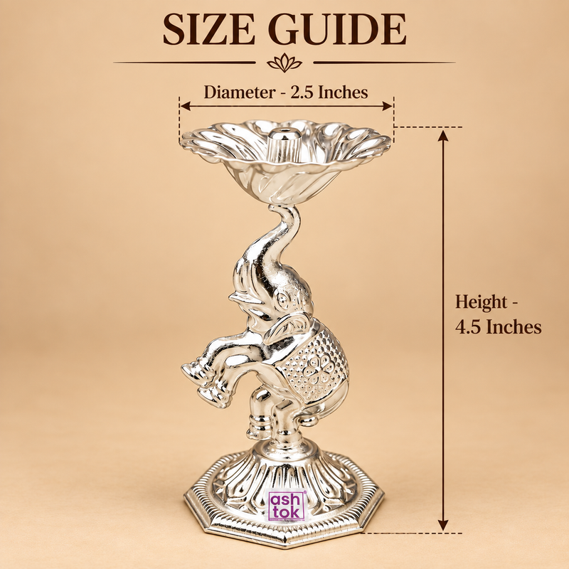 German Silver Elephant Pooja Diya size guide showing approximately 2.5 inch diameter and 4.5 inch height, featuring a raised flower shaped diya bowl with central wick holder, decorative elephant motif and embossed octagonal base, presented on a beige background with measurement arrows to help customers understand the compact size for home temple use, pooja rituals, festive decoration and gifting.