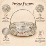 German Silver Flower Butti features image highlighting the bright polished silver finish, ornate floral cutwork side pattern, decorative engraved base, detailed metal craftsmanship, raised feet and elegant curved carrying handle, creating a traditional decorative basket suitable for festive occasions, wedding gifting, housewarming gifts, pooja arrangements, flower presentation, dry fruit gifting and decorative home use.