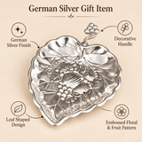 German silver gift item with leaf-shaped design, decorative handle, embossed floral and fruit pattern, and polished silver finish.