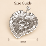 German silver gift item leaf-shaped serving dish with decorative handle and embossed design, shown with 12 inch size guide on beige background.